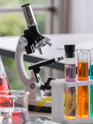 a microscope with several colorful test tubes full of liquid