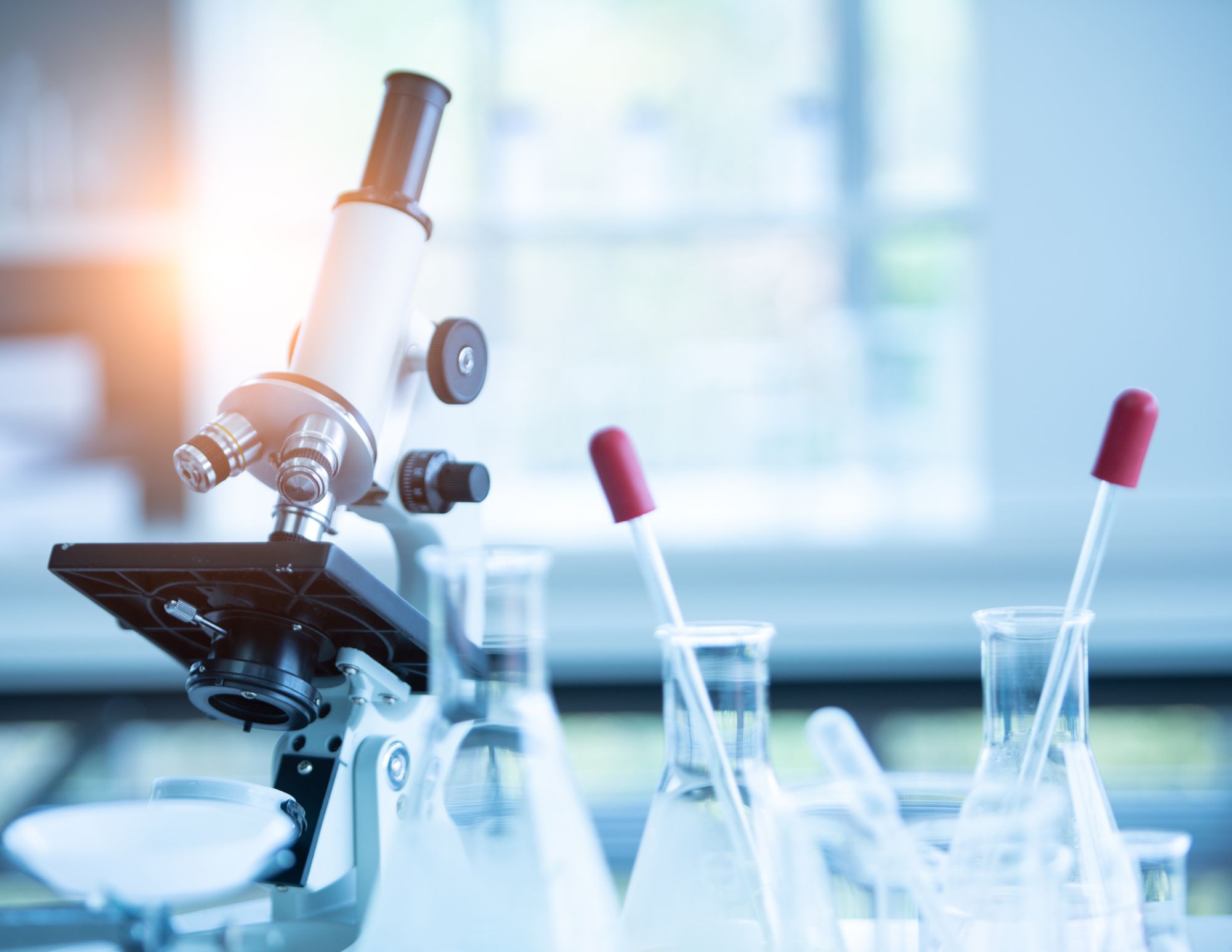 a microscope with several beakers testing samples for functional lab tests