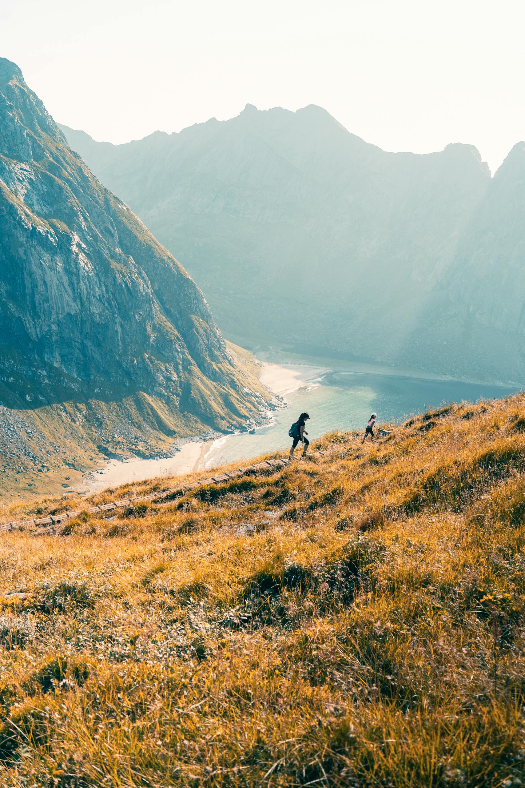 Two hikers explore the stunning landscapes of Fredvang, Norway.